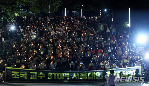 [ 지난 23일 서울대학교 아크로 광장 인근에서 열린 '조국 교수 STOP! 서울대인 촛불집회'에서 서울대학교 대학생들을 비롯한 참가자들이 촛불을 들고 있다.  / 사진 = 뉴시스 ]