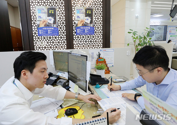 [ 서울 중구 NH농협은행 본점 영업점에 마련된 '서민형 안심전환 대출' 전담창구에 고객이 신청서를 작성하고 있다. / 사진 = 뉴시스 ]