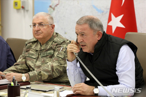 [ 훌루시 아카르 터키 국방장관이 9일(현지시간) 터키 앙카라에 위치한 육군본부 작전실에서 통화를 하고 있다. 터키 국방부는 이날 "터키군은 '평화의 샘' 작전의 하나로 공군 등 지원 사격을 통해 테러조직 181개를 타격했다"고 발표했다 / 사진 = 뉴시스 ]