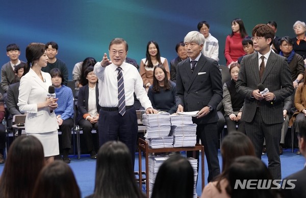 문재인 대통령이 19일 오후 서울 MBC 미디어센터에서 열린 '국민이 묻는다, 2019 국민과의 대화'에 참석해 국민패널과 온라인 참여자 질문지를 받고 있다. [사진=뉴시스]