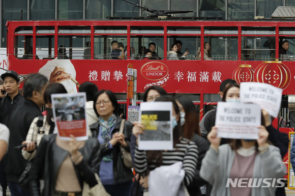 지난 2일(현지시간) 트램에 타고 있는 홍콩 시민들이 시위대의 시위 모습을 바라보고 있다. 수개월에 걸친 홍콩 민주화 운동이 새해에도 이어지면서 1일 주최 측 추산 100만여 명이 참여한 대규모 도심 시위가 벌어졌다. [사진=뉴시스]