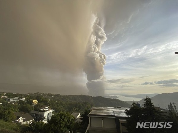 [ 12일 필리핀 수도 남쪽 호수의 한 섬에 소재한 탈 화산에서 연기와 재가 분출해 하늘로 치솟고 있다 / 사진 = 뉴시스 ]