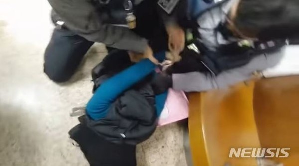 지난달 서울 잠실역에서 경찰 두명이 한 여성의 등 뒤로 수갑을 채우고 있다. [사진=뉴시스]