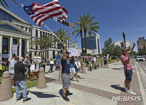 [ 21일(현지시간) 미국 플로리다주 잭슨빌 듀발 카운티 법원 앞에서 시민들이 신종 코로나바이러스 감염증(코로나19)으로 중단된 경제 활동을 재개하라고 시위 중 이다 / 사진 = 뉴시스 ]