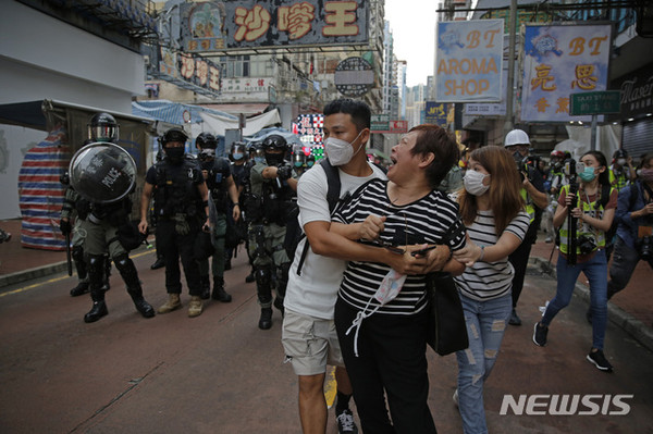 [ 홍콩 몽콕에서 한 여성이 시위 지역에 접근하지 말라는 경찰의 경고에 언성을 높이며 말다툼을 하고 있다 /  사진 = 뉴시스 ]