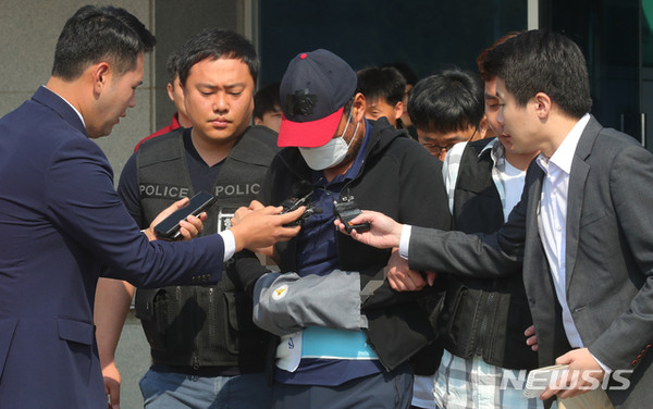 아내를 폭행해 숨지게 한 유승현 전 김포시의회 의장이 23일 오전 경기 김포시 김포경찰서에서 검찰에 송치되며 취재진의 질문을 받고 있다. [사진=뉴시스]