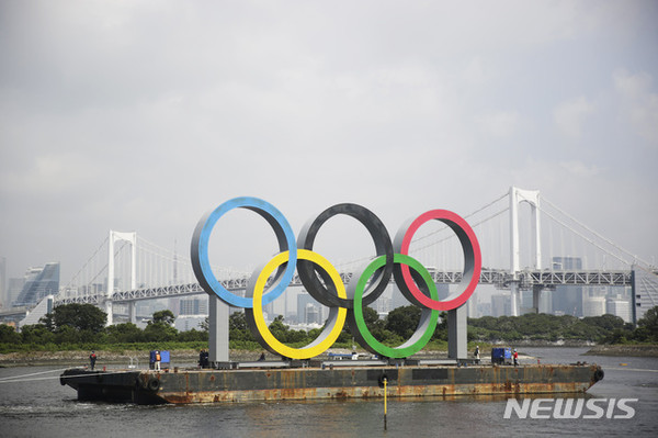 [ 6일 일본 도쿄 오다이바 해양공원 바지선에 설치됐던 2020 도쿄 올림픽&패럴림픽 오륜 조형물이 예인선에 이끌려 이동하고 있다 / 사진 = 뉴시스 ]