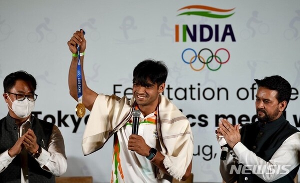 도 육상의 첫 금메달리스트 니라지 초프라(가운데)가 9일(현지시간) 인도 뉴델리에서 열린 2020 도쿄 올림픽 선수단 환영회에 참석해 금메달을 들어 보이고 있다./사진=뉴시스 제공.