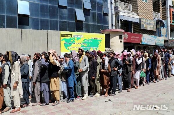 아프가니스탄 카불의 한 은행 앞에 아프간 주민들이 길게 줄 서 있다./사진=뉴시스 제공