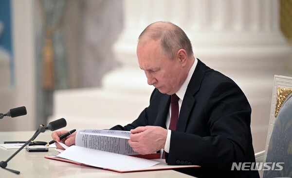 블라디미르 푸틴 러시아 대통령이 21일(현지시간) 모스크바 크렘린궁에서 우크라이나 동부 분쟁 지역인 돈바스 지역(도네츠크, 루한스크)의 독립을 인정하는 문서에 서명하고 있다./사진=뉴시스 제공