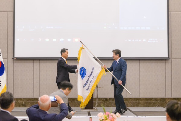 한국자유총연맹 강석호 총재가 태국지부 깃발을 김장렬 태국 지회장에게 전달하고 있다/사진=자유총연맹 제공.