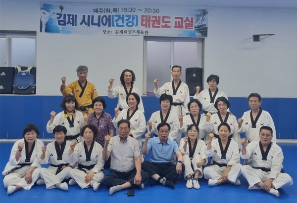 김제 시니어태권도 경락품세 교실에서 오는 9월 무주태린이페스타에 참가하기 위해 최재균 전북시니어태권도협회 상임부회장(경락품세 지도단장)지도 후 합동사진 촬영.가운데 중앙 흰색 티셔츠 착용, 전북시니어태권도협회 정선진회장. 맨뒷편에 노란색 태권도복을 착용한 최재균 경락품세 지도단장/사진=전북시니어태권도협회 제공